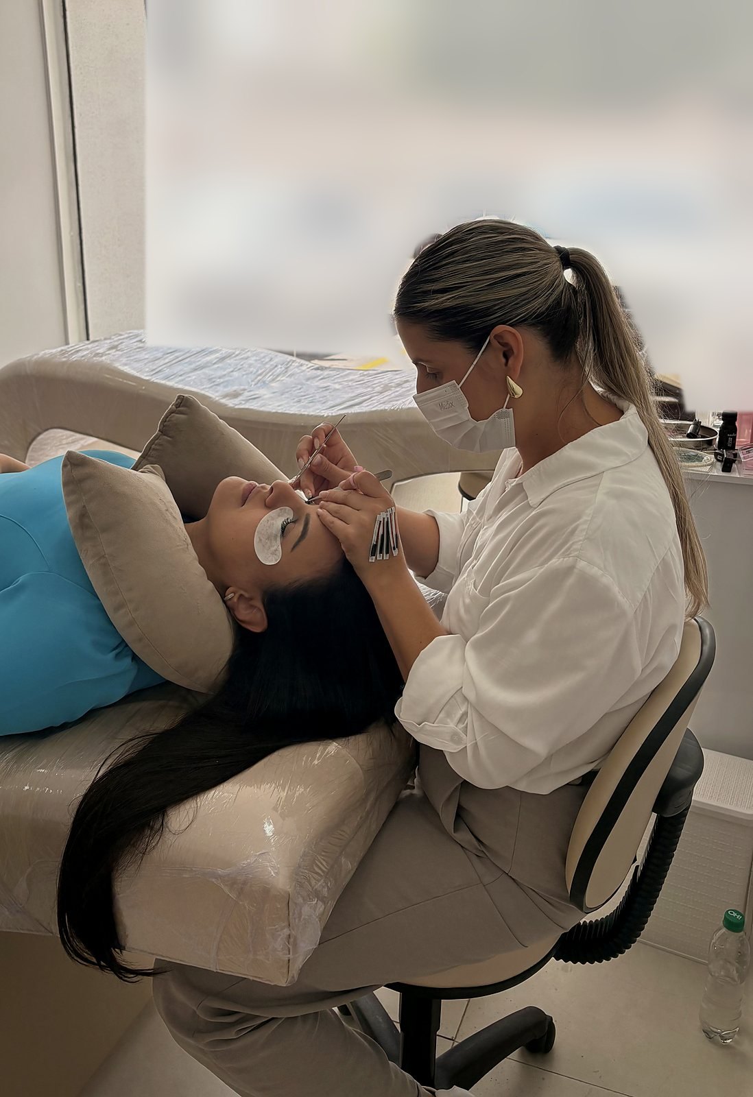 Lilian Cristina aplicando extensão de cílios em uma cliente no Studio