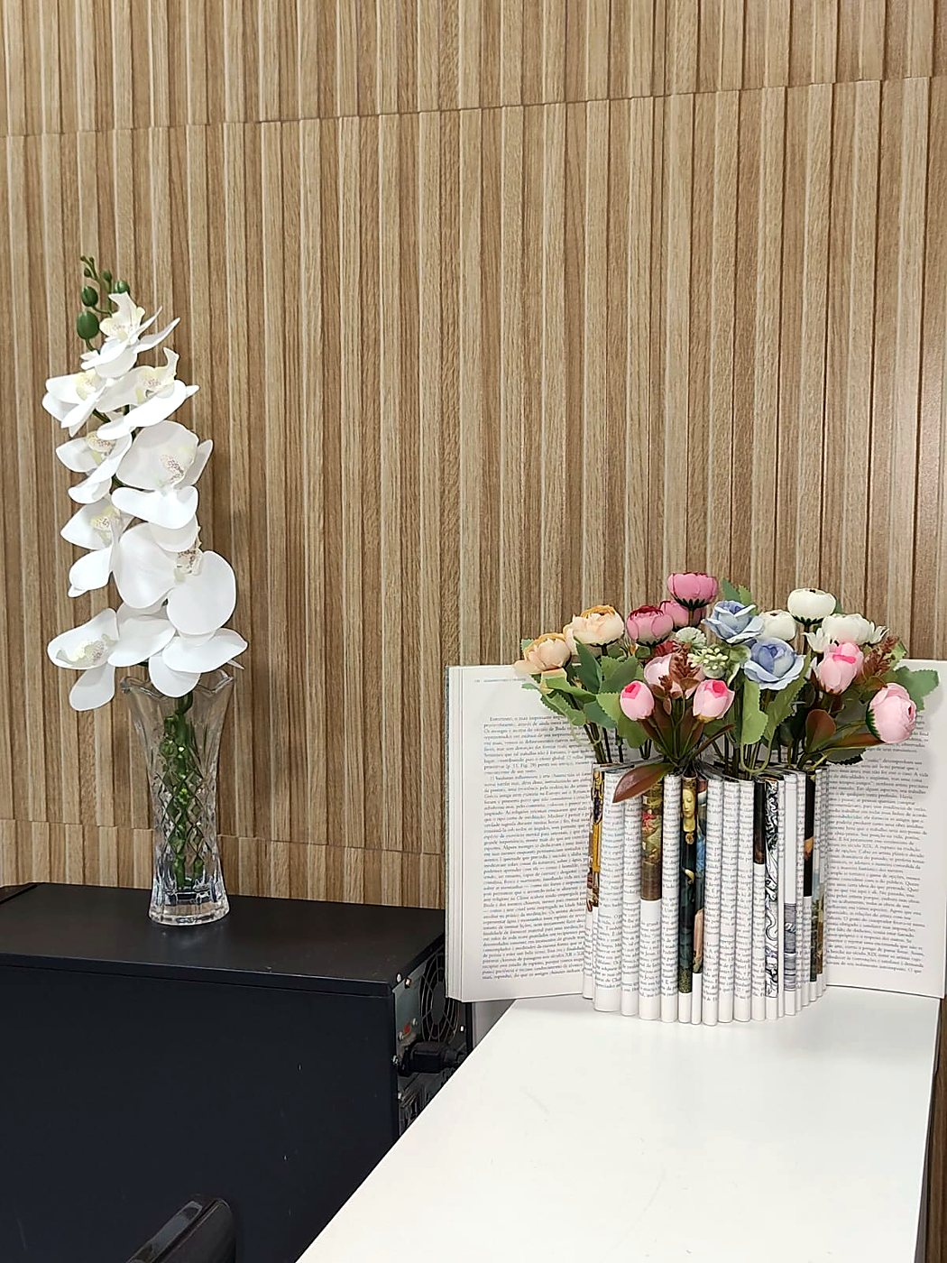 Orquídea branca e vaso de flores feito com páginas de livro